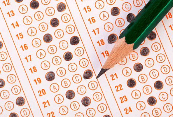 close up image of test answer sheet with darkened circles and a pencil hovering over.