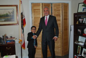 a young boy meeting with a legislator advocating for private homeschooling in his office at the California State Capitol